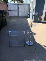 Overall view of the metal shoe tree and two-tier shelf rack on outdoor concrete area.