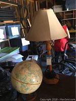 Photo showing the pineapple outdoor table lamp beside the decorative globe, highlighting lamp's pineapple design and the shade.