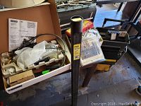 Tool box with manuals, more tools, and parts in a box, including a Delta manual visible