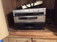 Stacked electronics including Sansui VHS/DVD player, Technics AM/FM stereo receiver, and Technics CD changer