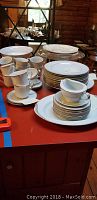 White china plates, cups, saucers, and serving dishes arranged on a table