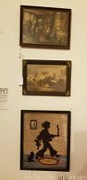 Photo of two large framed antique hand-colored prints stacked vertically on a wall above a smaller framed fabric picture silhouette.