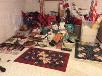 View of assorted holiday decorations, Easter bunny plush, decorative snowman, poinsettias, wreaths, gift wrapping paper rolls, and boxed Pfaltzgraff Winterberry dish