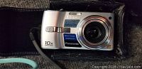 Front view of Panasonic Lumix DMC-TZ1 digital camera showing 10x optical zoom lens and protective black case