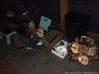 Wide view showing assortment of items including vases, faux flowers, blower, signs, cooler and rugs