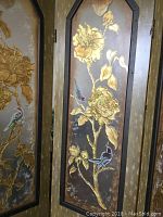 Close-up photo of one panel of the room divider showing etched glass with gold gilded floral and bird motifs