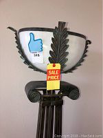 Close-up photo of the frosted glass bowl-shaped shade accented with decorative metal leaves and scrollwork under the shade.