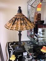 Full view of the lamp showing the rice paper lampshade with black bamboo brush designs and the ornate base.