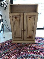 Front view of the closed wooden cabinet showing the double doors and panel detail.