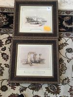 Two framed prints side by side on a patterned carpet, showing the overall lot of religious themed framed art prints.