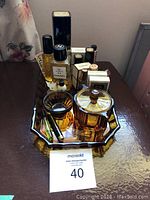 View of Chanel perfume bottles including Chanel No 5, Tabac, and various smaller bottles along with amber glass containers on tray.