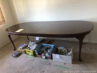 Full view of solid cherry wood dining table with two leaves, showing the overall size and shape.