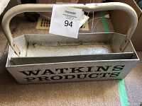 Front side of the metal bin with handle showing 'Watkins Products' branding