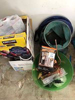 Overview of lot contents showing assorted boxes including Kirkland prune boxes, plastic bags, and collapsible bins containing copper and miscellaneous items.