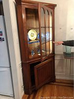 Front angle showing upper glass display doors and lower wood door