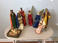 Italian paper mache nativity scene set with 10 figurines including Mary, Joseph, baby Jesus in manger, three wise men, two angels, a shepherd, and another female figurine. Some figures display missing hands and repaired damage.