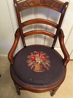 Front view of the wooden chair with needlepoint floral seat.