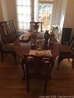 Front view of the cherry wood dining table with chairs around it, shows overall condition and style.