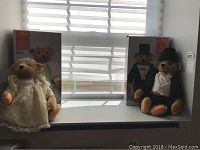 Bride and groom Steiff bears seated beside their original boxes on a windowsill, with daylight providing natural lighting.