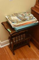 Wooden magazine table placed near wall with assorted placemats and coasters stacked on top.