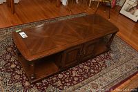 Full view of rectangular oak coffee table with patterned wood veneer top and lower open shelf.