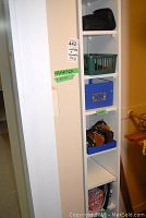 Shelving unit with multiple compartments holding wallets, cosmetic bags and coin purses organized inside plastic containers.