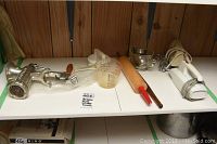Overview of lot showing meat grinder, measuring cups, rolling pin, mixing bowls, and electric hand mixers on white shelf