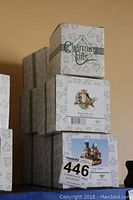 Stacked original boxes of six Fitz and Floyd Charming Tails figurines, visible labels for Happy Holly Days and others.