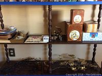Shelf with various decorative and collectible items including small boxes with animal prints, framed art, and figurines.