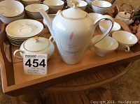 Full set displayed on wooden tray showing teapot, sugar bowl, creamer, six cups and six plates.