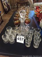 Crystal decanter with various sets of glasses including amber stemmed and etched clear glasses