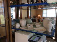 Display shelf with multiple Lenox porcelain items including vases, tray, bowl, and trinket box arranged together.