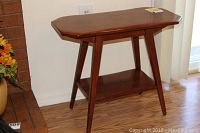 Side view of the Cushman Colonial side table showing angled legs and lower shelf.