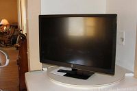 Westinghouse 32 inch LED HDTV on a white round table in a room with wooden furniture visible in the background.