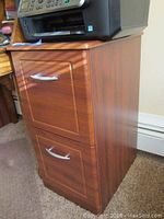 Front and side view of the filing cabinet showing wood finish, two drawers, and silver handles.