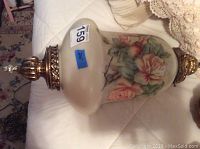 Full view of the hanging light showing floral painted glass and brass fittings