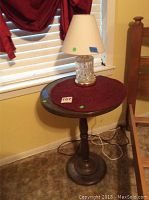Full view of the brass table with wooden top and glass table lamp on it, showing size and condition.