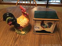 Photo of ceramic rooster cookie jar and wooden storage box on a wooden table