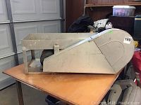 Side view of electric black-eyed pea huller showing overall metal body and chute.