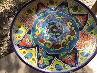 Close-up of top basin showing detailed floral multicolor design and wear/chipping areas.