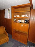 Full view of vintage mid-century modern faux wood cabinet showing open shelves, flip-down middle door, and bottom double doors.