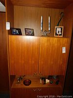 Full view of two shelves containing figurines, photo frames, and candlesticks.