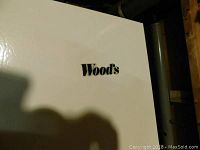 Close-up photo of Woods brand logo on the freezer door