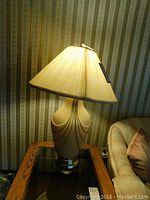 Table lamp lit showing design and fabric shade