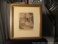 Framed hand colored lithograph depicting two Victorian-era women in dresses, titled 'La Mode Illustree', gold ornate frame
