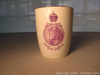 Full view of the oval beige ceramic mug with maroon/red crowned portrait of King Edward VII and Queen Alexandra dated June 1902.