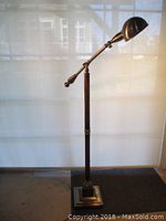 Full view of the bronze floor lamp with a rectangular base and adjustable arm, standing at about 45 inches tall to the arm.