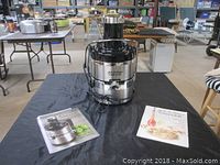 Full shot of the Jack La Lanne Power Juicer placed on a black cloth with two manuals beside it, showing its size and condition.