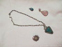 Full lot image showing all four pendants including the necklace with turquoise-colored pendant, pink pendant, blue-green pendant, and crystal geode pendant.