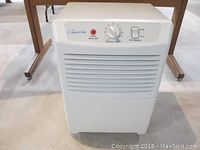 Front view of white Comfort Aire dehumidifier showing air vent grille and control panel.